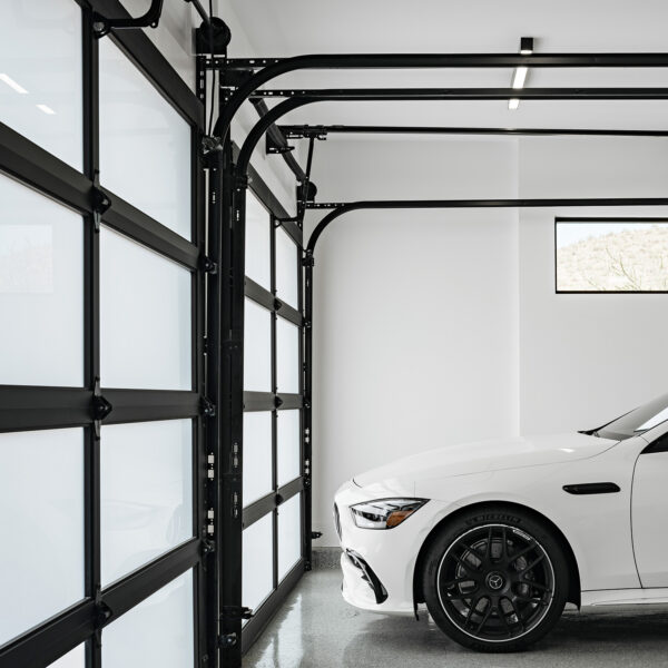 Modern Glass Garage Door Modern garage interior with glass panel garage door and white sports car in clean minimalist space.